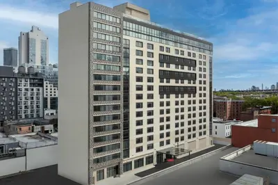 a tall white building on top of a city at SpringHill Suites by Marriott New York Queens in Queens