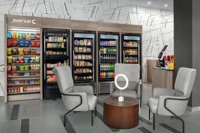 a grocery store with two chairs and a table and drinks at SpringHill Suites by Marriott New York Queens in Queens