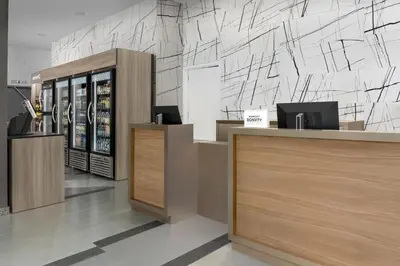 a store lobby with wooden counters and a wall at SpringHill Suites by Marriott New York Queens in Queens