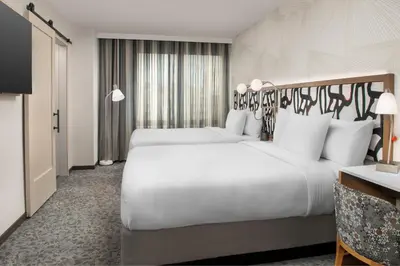 a hotel room with two beds and a television at SpringHill Suites by Marriott New York Queens in Queens