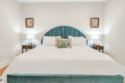 a bedroom with a large bed with a blue headboard at SkyHouse JC - New 3BR Apt with Private Rooftop in Jersey City