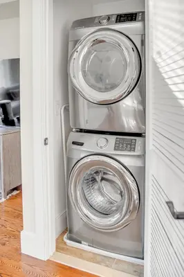 a washing machine and a washer and dryer in a room at SkyHouse JC - New 3BR Apt with Private Rooftop in Jersey City