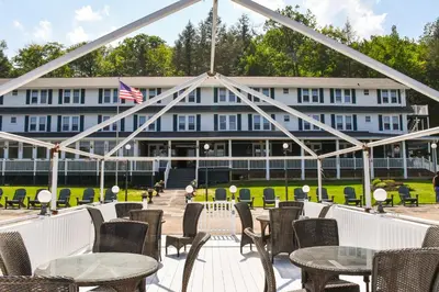 a view of a building with tables and chairs at Chestnut Inn at Oquaga Lake in Deposit