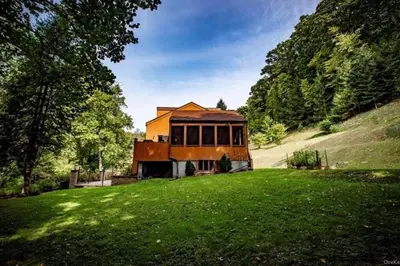 a house sitting on top of a lush green field at Modern, Cozy Hudson Valley Escape 1 Hr From NYC in Putnam Valley