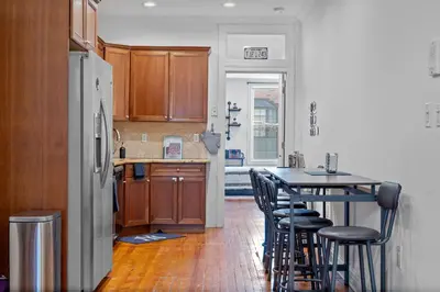 a kitchen with wooden cabinets and a table with chairs at Large Home - Great Location - 15 Minutes to NYC in Hoboken