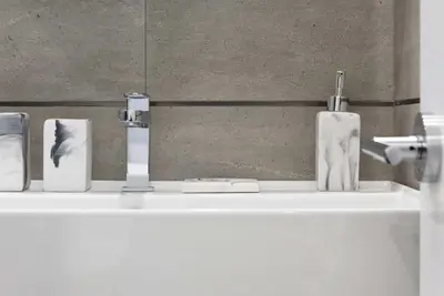 a bathroom sink with three soap bottles on it at 78-3C Newly renovated 1BR WD Walk 2 Central Park in New York