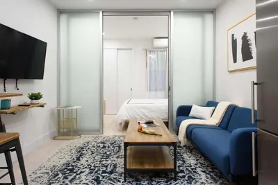 a living room with a blue couch and a bed at 78-3C Newly renovated 1BR WD Walk 2 Central Park in New York