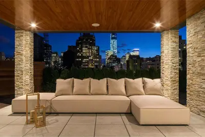 a large white couch sitting on a patio with a view of a city at Rasila SoHo in New York