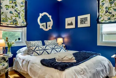 a blue bedroom with a bed with a blue wall at 1890 CapeCod farmhouse:Charming, Private, Spacious in Saugerties