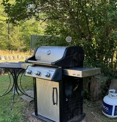 a grill sitting on top of a table in a yard at 1890 CapeCod farmhouse:Charming, Private, Spacious in Saugerties