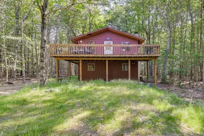 a house with a deck in the woods at Gouldsboro Vacation Rental with Pool and Lake Access! in Gouldsboro