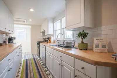 a kitchen with white cabinets and a wooden counter top at Entire House Right In Stamford's Heart in Stamford