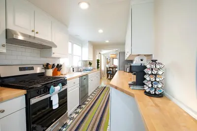 a kitchen with white cabinets and a stove top oven at Entire House Right In Stamford's Heart in Stamford