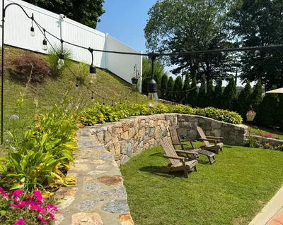 a garden with two benches and a stone wall at Entire House Right In Stamford's Heart in Stamford