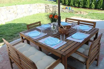 a wooden table with plates and glasses on it at Entire House Right In Stamford's Heart in Stamford