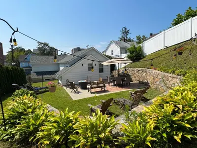 a backyard with a patio with tables and chairs at Entire House Right In Stamford's Heart in Stamford