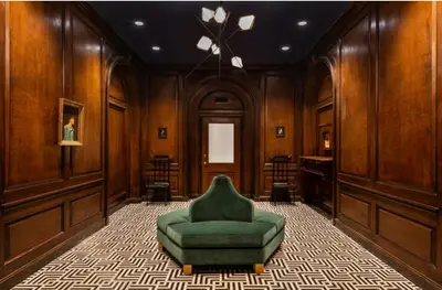 a green chair in a room with wooden walls at FiDi Studio w Gym Lounge Complete Gym NYC-499 in New York