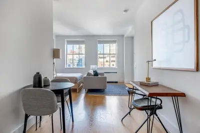 a living room with a couch and a table and chairs at FiDi Studio w Gym Lounge Complete Gym NYC-499 in New York