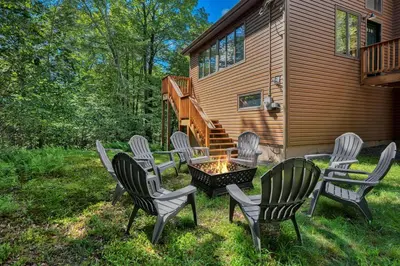 a group of chairs sitting around a fire pit in a yard at Serene & Fun Family Gem ~ Big Bass Lake Community! in Gouldsboro