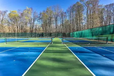 a tennis court with blue and green at Serene & Fun Family Gem ~ Big Bass Lake Community! in Gouldsboro