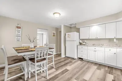 a kitchen with a table and a white refrigerator at North Haven Charm, 3BD Yale Retreat in North Haven