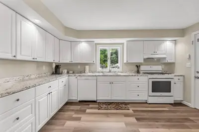 a white kitchen with white cabinets and a window at North Haven Charm, 3BD Yale Retreat in North Haven