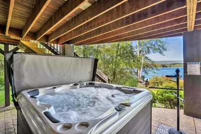 a hot tub on a patio with a view of the water at Lakefront Sunsets, Hot Tub, Pool Table, Kayaks in Lake Ariel