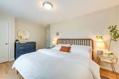 a bedroom with a large white bed and a blue dresser at Glen Cove Vacation Rental Less Than 1 Mi to Downtown! in Glen Cove
