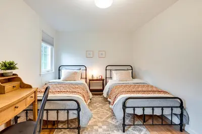 two beds in a room with white walls at Glen Cove Vacation Rental Less Than 1 Mi to Downtown! in Glen Cove