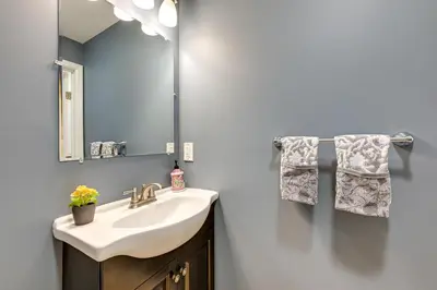 a bathroom with a sink and a mirror and towels at Glen Cove Vacation Rental Less Than 1 Mi to Downtown! in Glen Cove