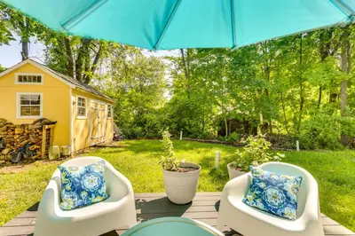 a patio with two chairs and an umbrella at All-Season Vernon Township Lake House Retreat! in Vernon Township