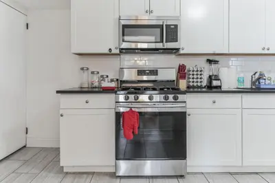 a kitchen with a stove and a microwave at Grace's Place - 3 Bedroom Townhouse in Greenwich in Greenwich
