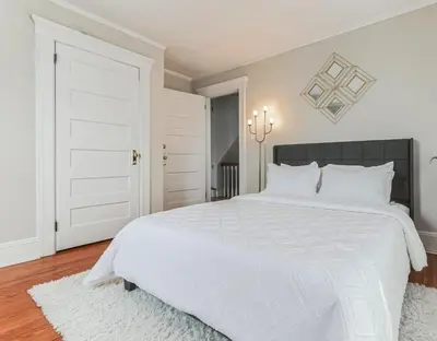 a white bedroom with a large white bed with white pillows at Grace's Place - 3 Bedroom Townhouse in Greenwich in Greenwich