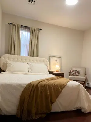 a bedroom with a large white bed and a window at Hudson Haven in Hudson
