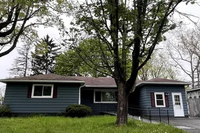 a blue house with a tree in the yard at Hudson Haven in Hudson