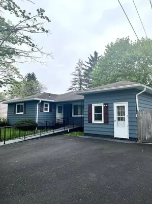 a small blue house with a fence in front of it at Hudson Haven in Hudson