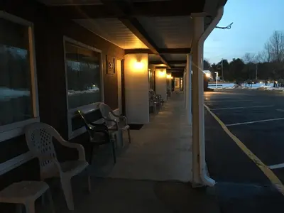 an empty building with chairs in a parking lot at Landmark Motor Inn in Glens Falls