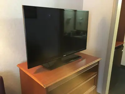 a flat screen tv sitting on top of a dresser at Landmark Motor Inn in Glens Falls