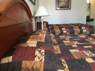 a bedroom with a bed with a quilt on it at Landmark Motor Inn in Glens Falls