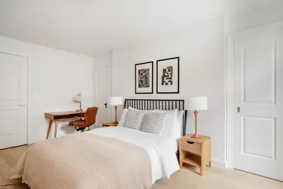 a white bedroom with a bed and a desk at Midtown East 1br w doorman nr Grand Central NYC-1170 in New York