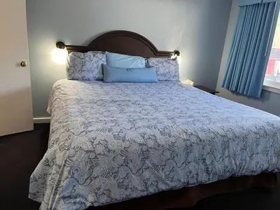 a bedroom with a bed with a blue and white comforter at Hitching Post Motel in Cornwall