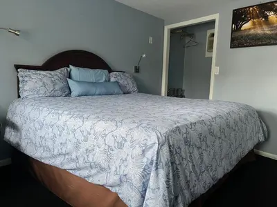 a bedroom with a large bed with blue pillows at Hitching Post Motel in Cornwall