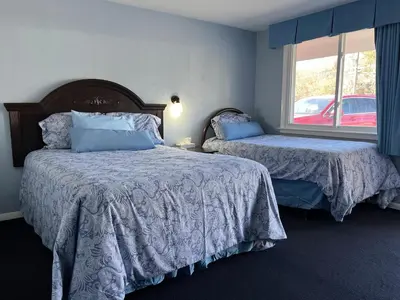 a bedroom with two beds and a window at Hitching Post Motel in Cornwall