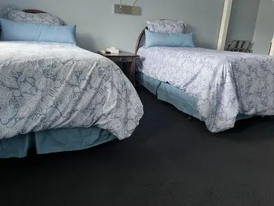 two beds sitting next to each other in a bedroom at Hitching Post Motel in Cornwall