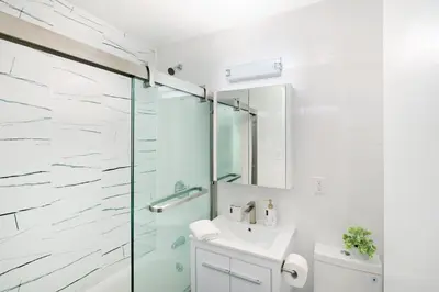 a bathroom with a sink and a glass shower at 444-3F Newly renovated 1BR in Hell's Kitchen in New York