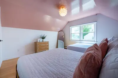 a bedroom with a large bed and a window at Fairfield Cottage -Top Rated Gem, Fire Pit, Near Beach, 90 Min to NYC in Fairfield