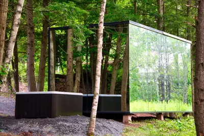 a glass house in the middle of a forest at The Haüs Windham - Spacious Suites, Hot Tub, Mountain Views! in Windham