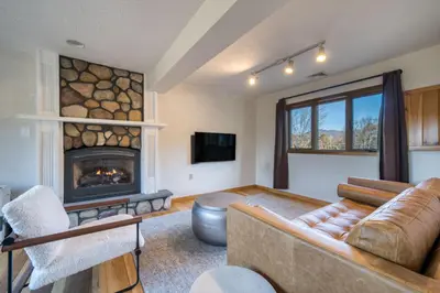 a living room with a couch and a fireplace at The Haüs Windham - Spacious Suites, Hot Tub, Mountain Views! in Windham