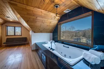a large bathroom with a tub and a large window at The Haüs Windham - Spacious Suites, Hot Tub, Mountain Views! in Windham