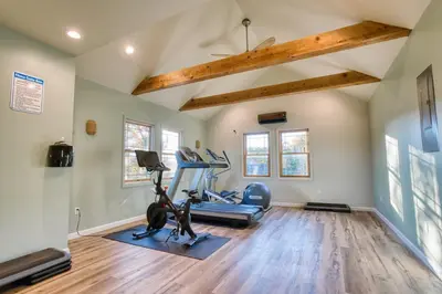 a gym with exercise equipment in a room with wooden floors at The Haüs Windham - Spacious Suites, Hot Tub, Mountain Views! in Windham